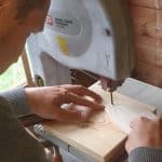 Elektrowerkzeuge wie die Kreissäge schneiden ein Stück Holz präziser und schneller