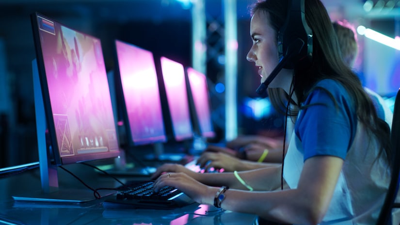 Mädchen sitzt vor einem Gaming Monitor und spielt ein Spiel