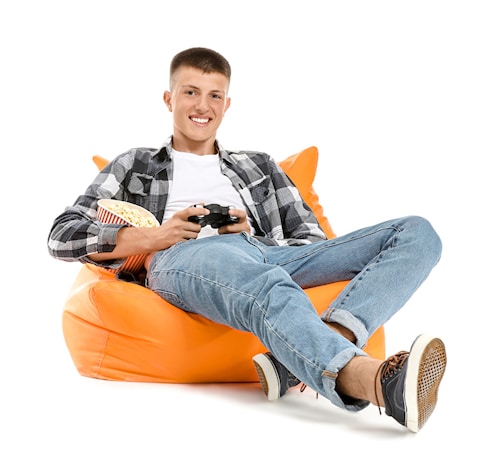 Teenager spielt auf einem Gaming Sitzsack an der Spielekonsole