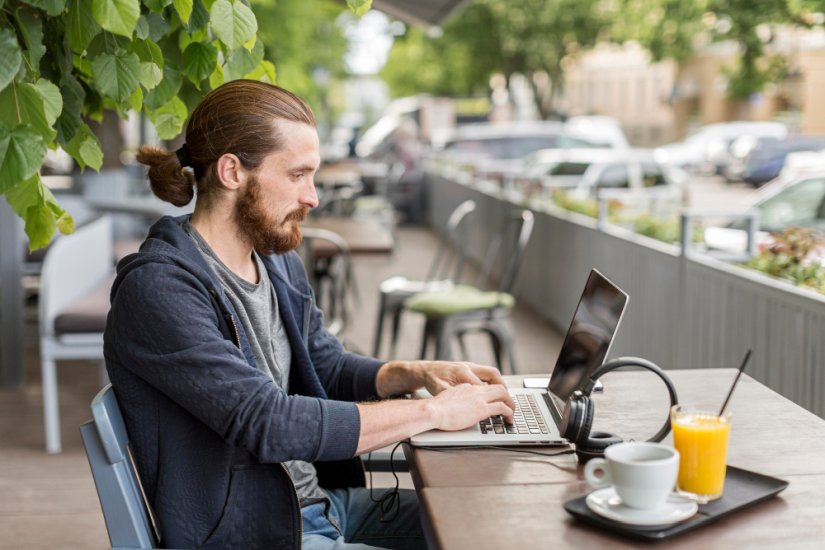 Mann sitzt im Cafe am Laptop und spielt in einem europäischen Casino